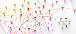 Linking entities. Networking, social media, SNS, internet communication abstract. Small network connected to a larger network. Web of red, orange and yellow wires on white background.