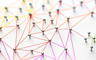 Linking entities. Networking, social media, SNS, internet communication abstract. Small network connected to a larger network. Web of red, orange and yellow wires on white background.