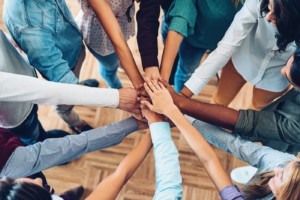 Group of people standing in circle and supporting each other